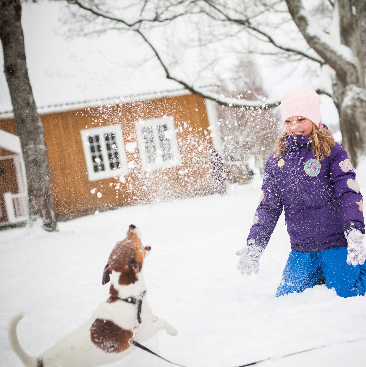 Barn og hund leker i snøen