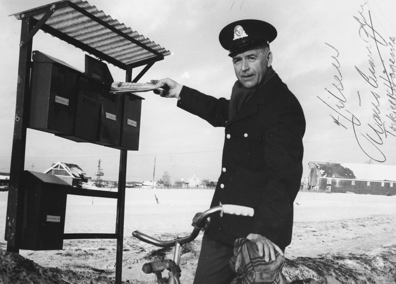 Postmann leverer post i postkasse.