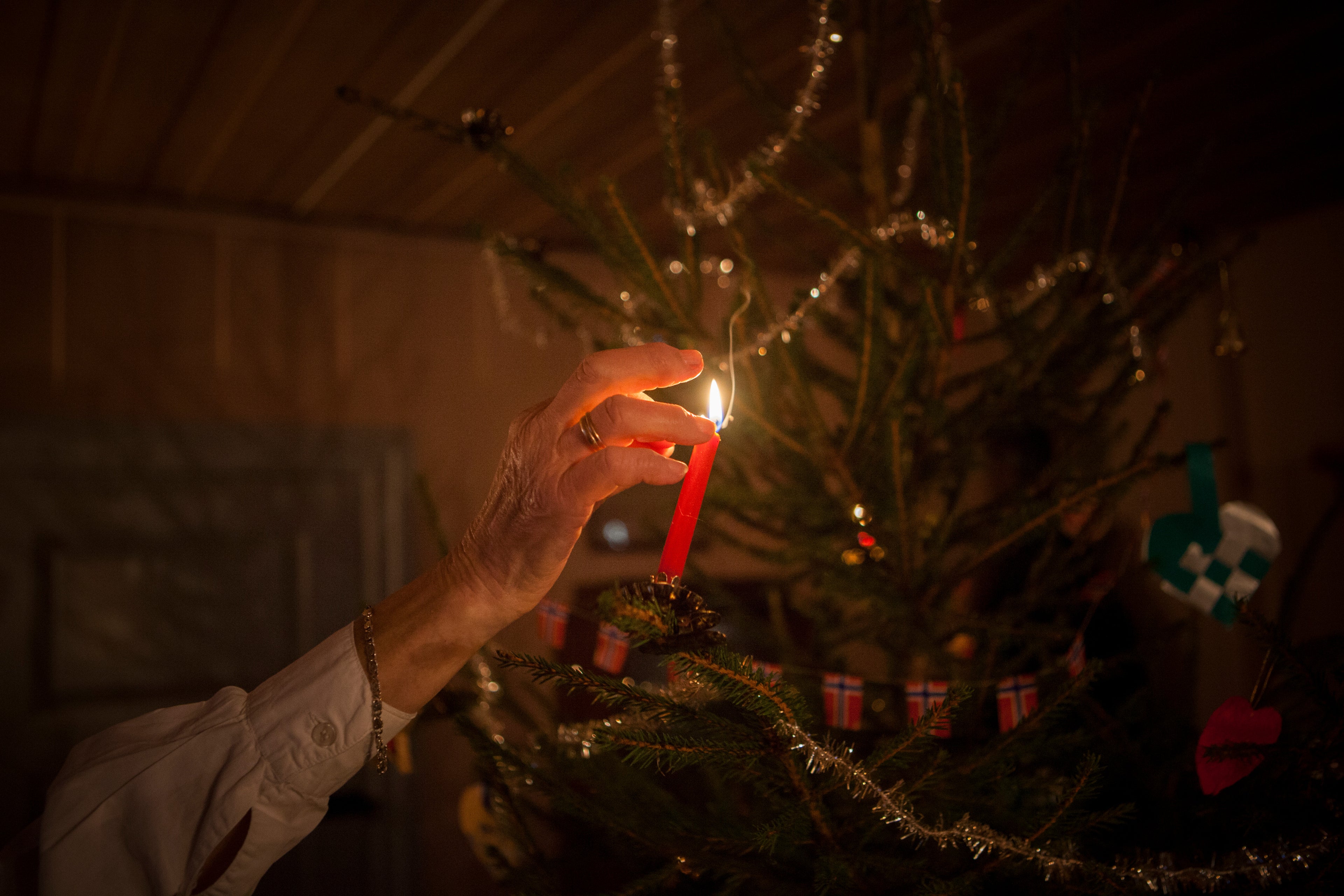 Hånd tenner jul på juletre